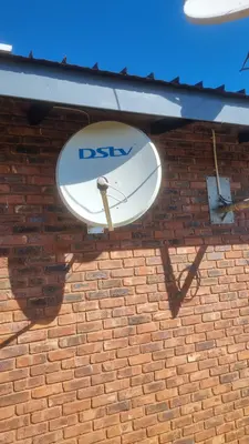 DStv satellite dish on brick facade angle view