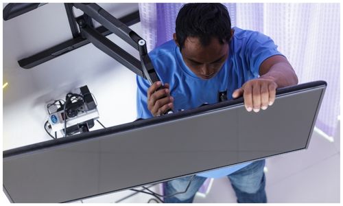 Technician wall-mounting a smart TV during a DStv Stream setup in Sandton