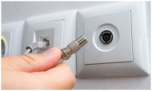 RG6 coaxial cable with an F-type connector being plugged into a DStv wall point